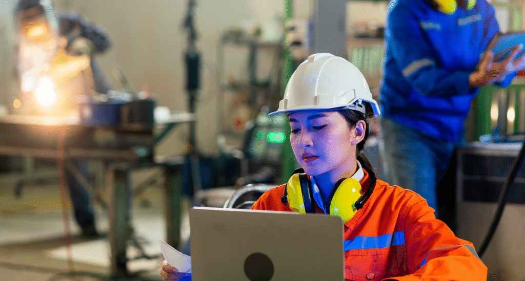 Industrial professional managing factory workflows via a cloud-based SaaS platform, showcasing the digital transformation of traditional industries through automated software integration.