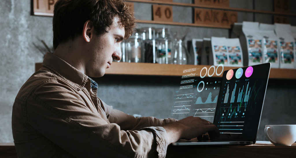 A person looking at a fluctuating digital chart overlay on a laptop, representing the shift toward demand-driven SaaS subscriptions and real-time financial tracking.